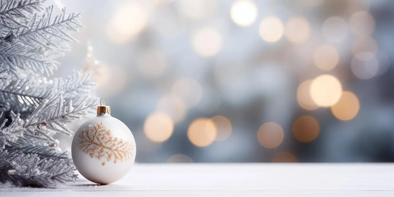 Leuchtender Weihnachtsschmuck mit einem Baum sanft im Hintergrund.
